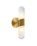 Brass wall sconce with a slim vertical textured glass tube, softly illuminated and held at the center by a curved brass band, mounted on a round brass wall plate.