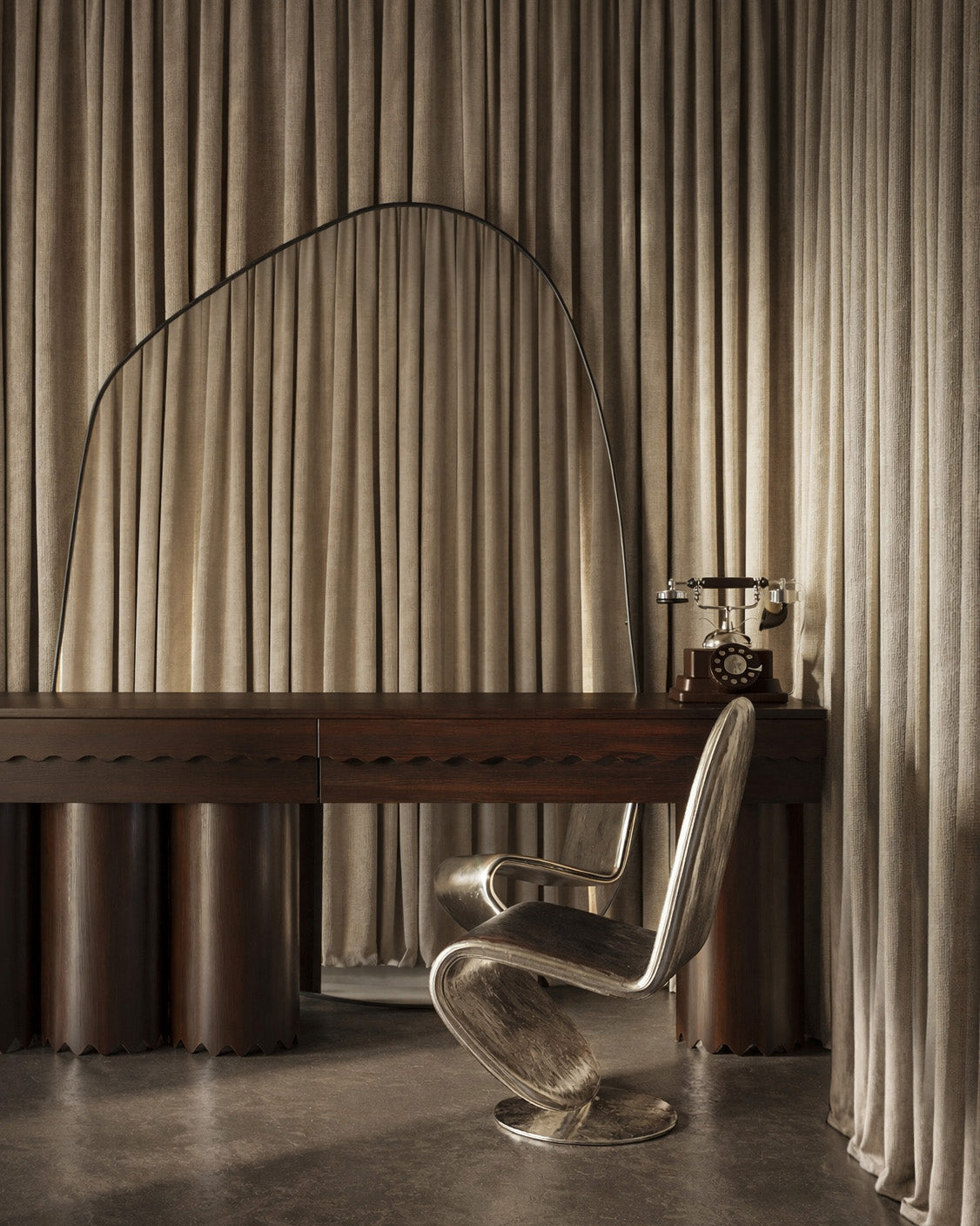 XXL organic wall mirror with black frame positioned above a dark wood desk with a chair and rotary phone.