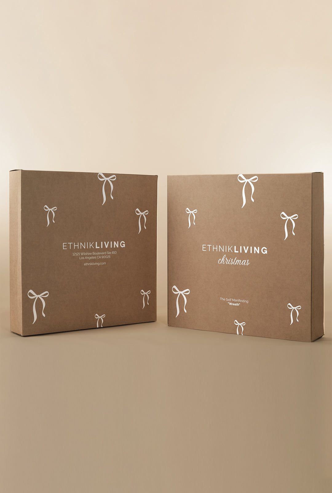 Two Ethnik Living Christmas wreath packaging boxes displayed side by side, made of kraft paper with white bow illustrations and branded text on the front.
