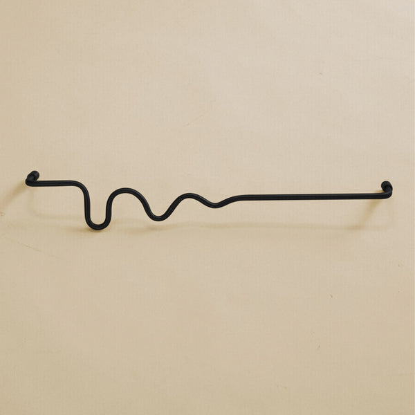 Black-colored towel bar with a wavy organic shape, shown in a studio setting on a neutral background.