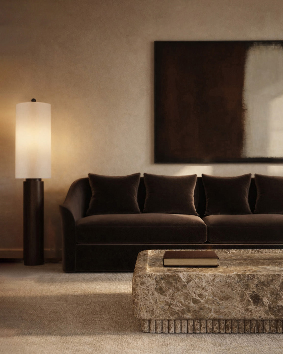 Dark brown sofa with pillows, marble coffee table with a book, and a tall floor lamp beneath a large abstract wall art in a warm-toned living room.