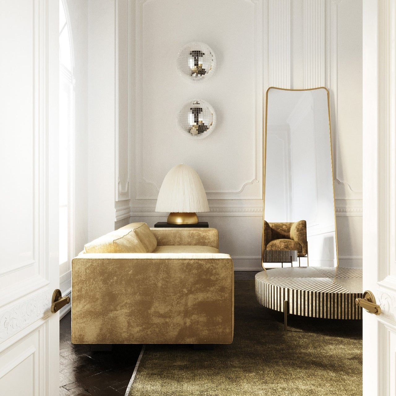 Interior scene showing a tall full-length mirror with softly curved edges placed against a wall, reflecting an armchair, with a sofa, table lamp, and decorative wall elements arranged in the room.