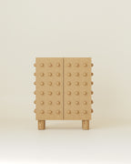 Wooden storage cabinet with a clean rectangular form, featuring evenly spaced rounded wooden spheres across both front doors, standing on short cylindrical wooden legs.