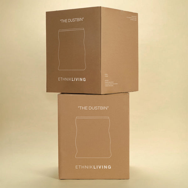 Two stacked brown product boxes labeled “THE DUSTBIN” with the brand name “ETHNIK LIVING,” featuring a line illustration of the dustbin on the front, against a light yellow background.