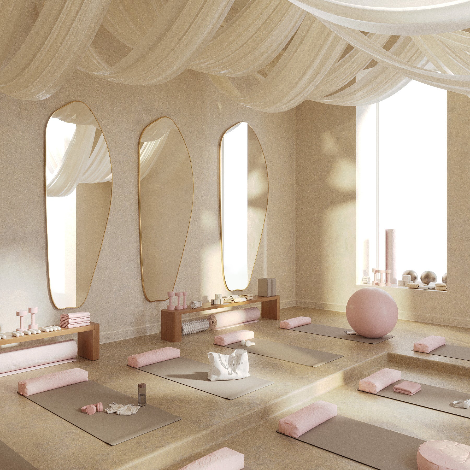 Minimalist pilates studio featuring multiple asymmetrical brass-framed full length mirrors, yoga mats, and soft pink accessories.