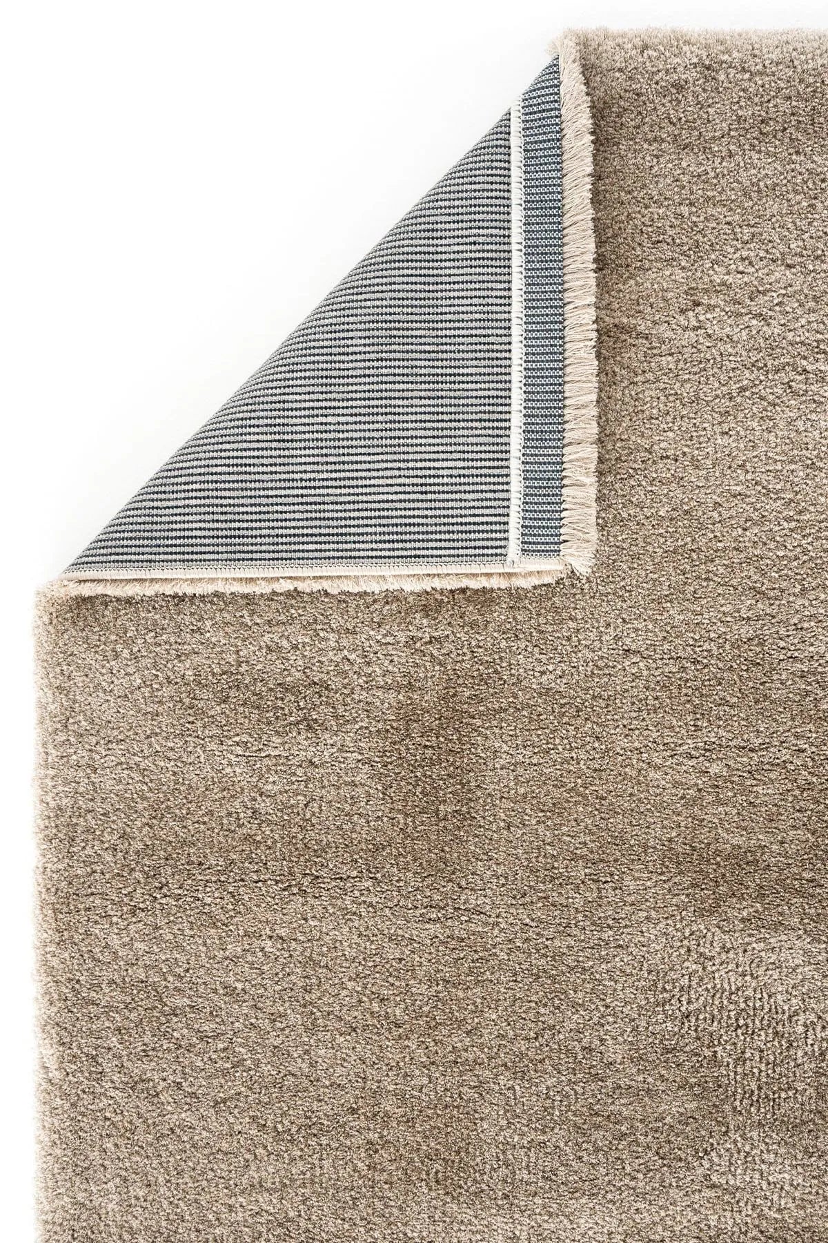 Close-up of a brown plush rug showing thick pile and woven backing.