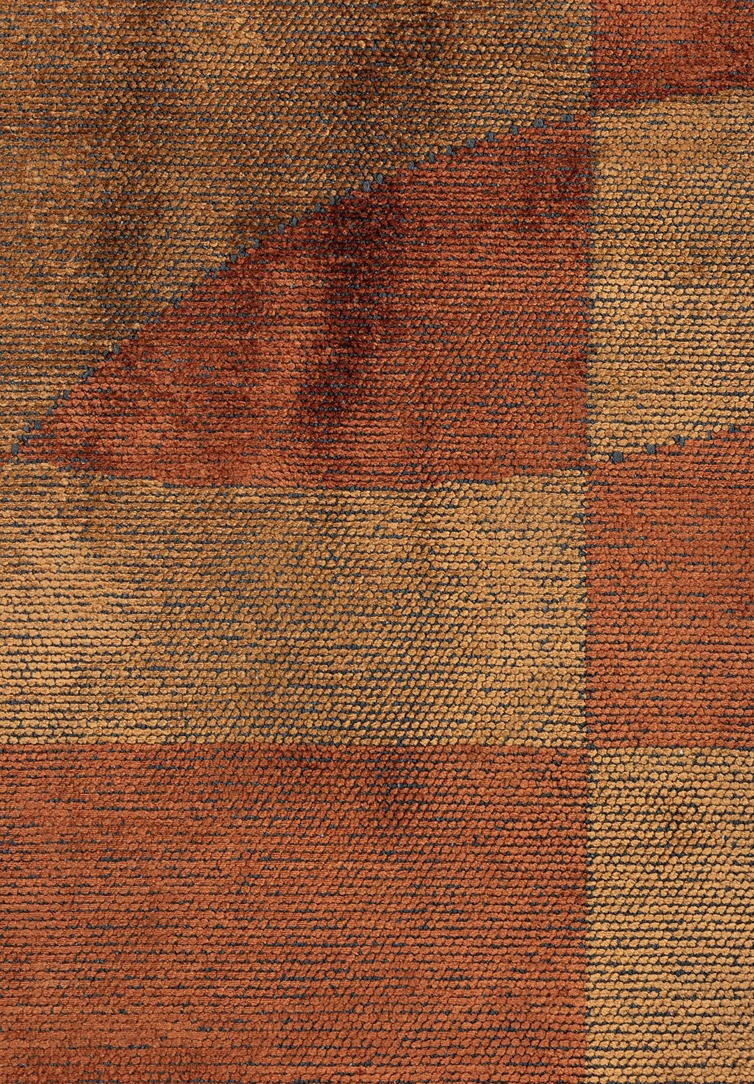 Detailed close-up of a flat-woven rug showing a checkerboard pattern in warm caramel, rust, and golden tan tones, highlighting the dense weave, subtle color variation, and richly textured surface.