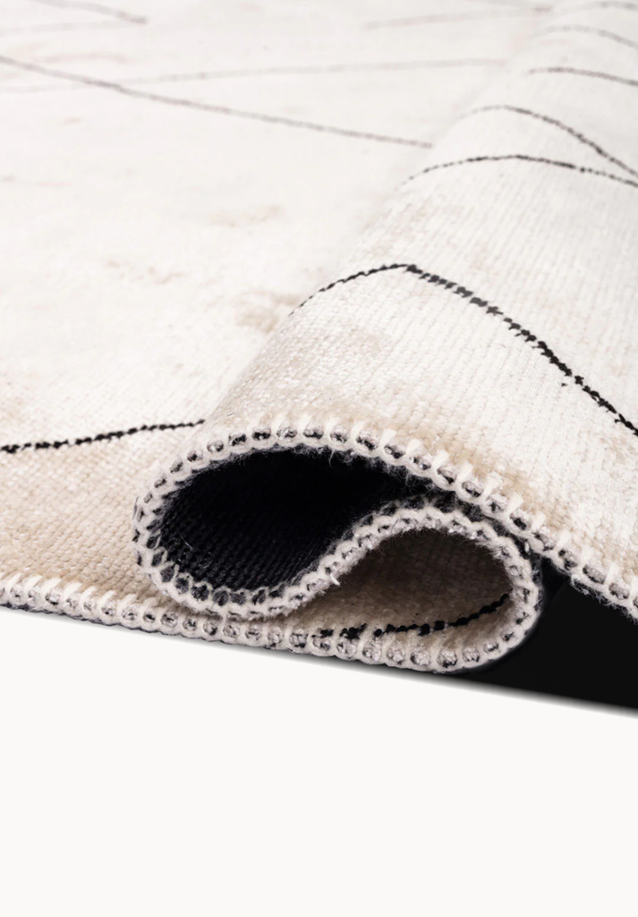 Close-up of a beige rug with thin black lines.