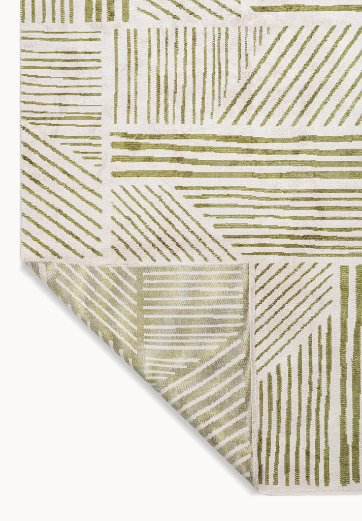 Folded corner of a beige rug with green linear geometric pattern.