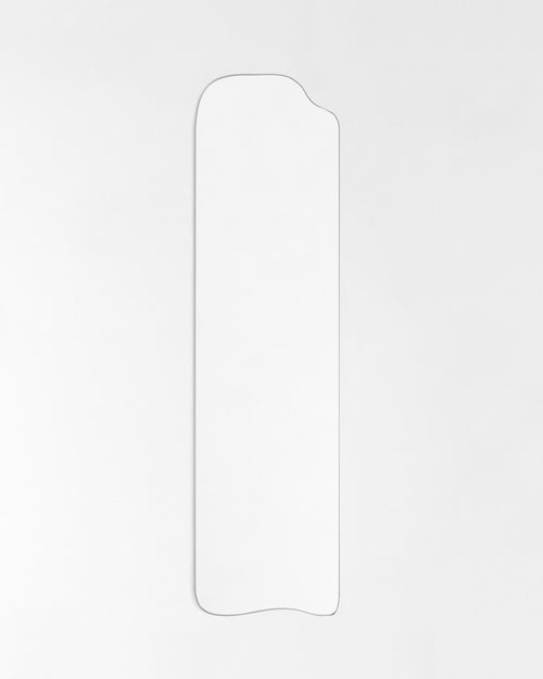 Asymmetrical full-length mirror with an organic silhouette and thin frame, shown against a plain white background.